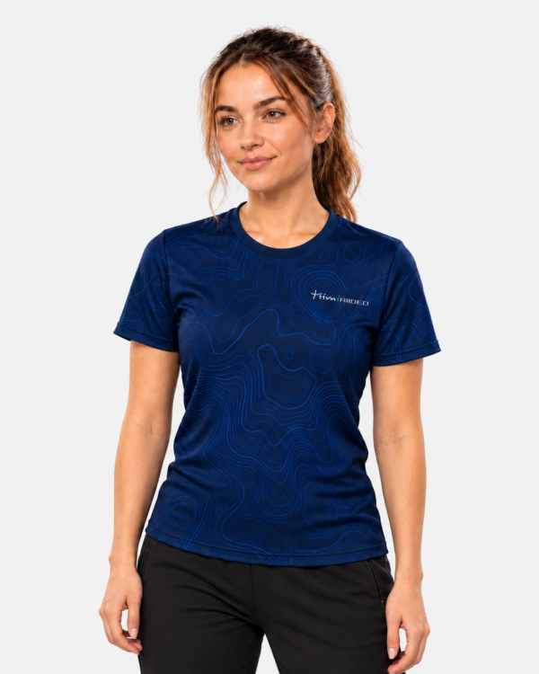 Naine kannab tumesinist siniste topograafiliste joontega Classic e-spordisärki, Tiimiriided logo rinnal.