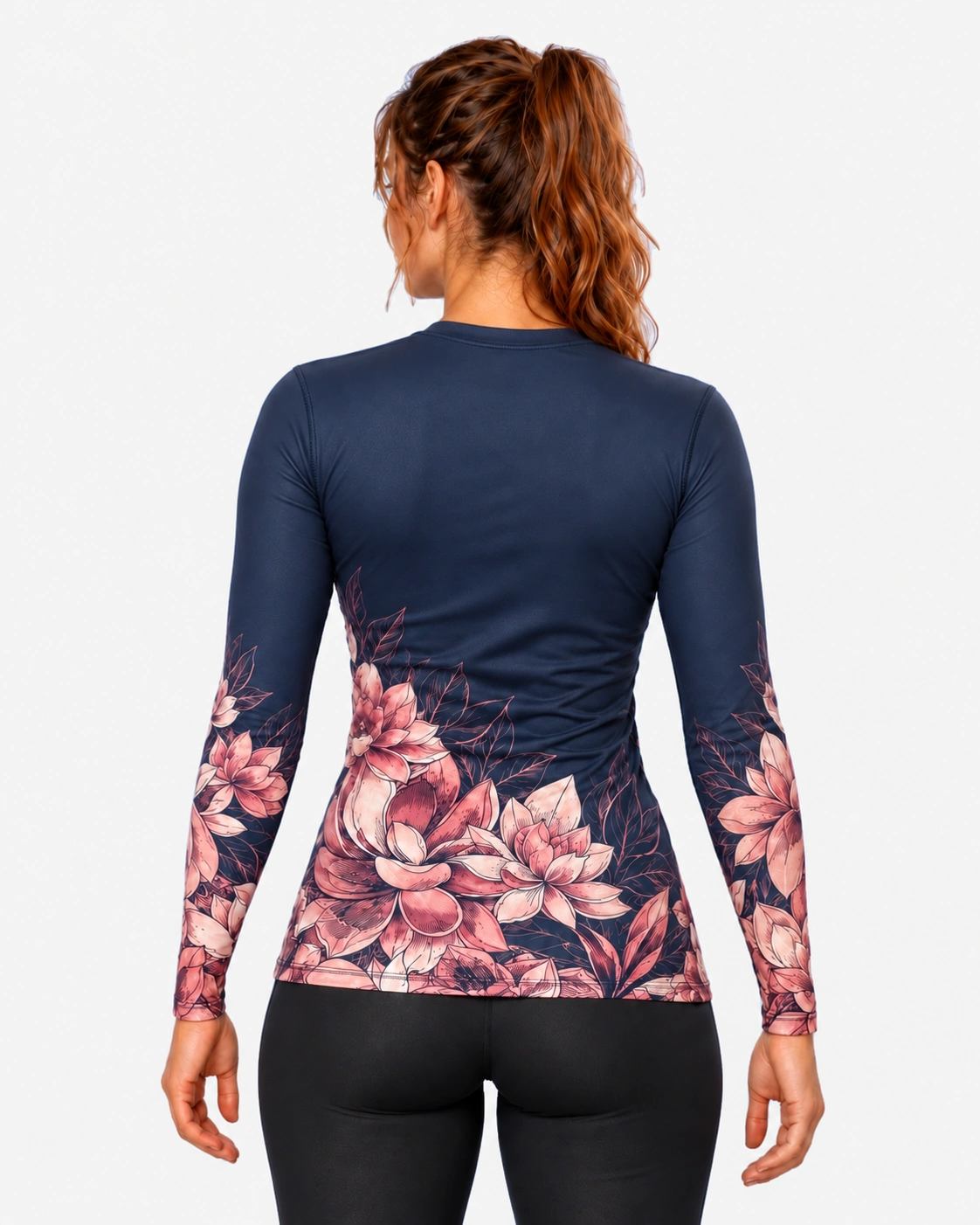 Indigopõhjal roosade õitega pikkade varrukatega rashguard naise seljas, tagantvaade.